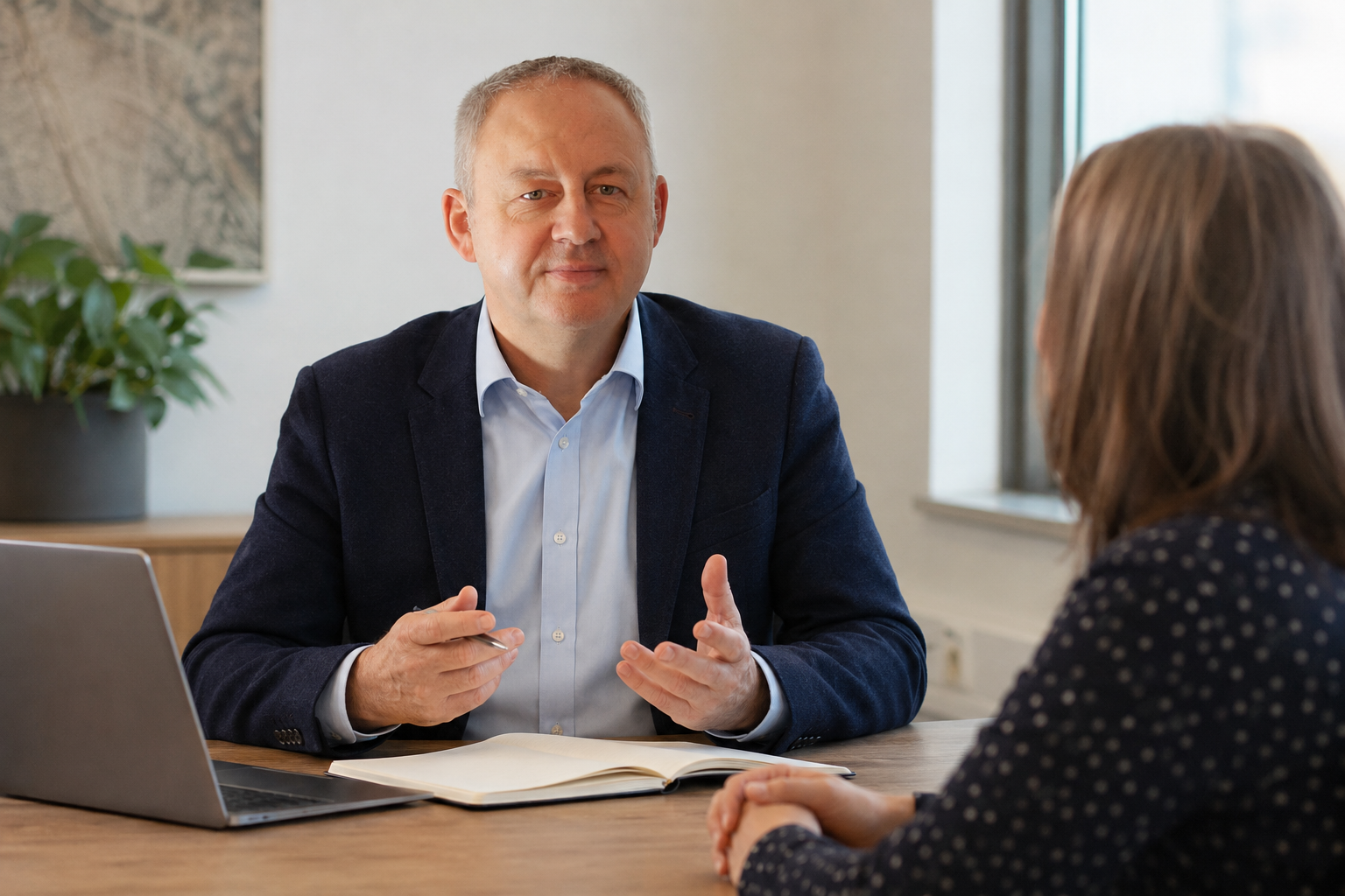Derek Carter discussing onboarding documents with a client manager across a desk